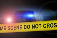 police crime area tape with car in back at night