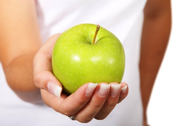 woman holding green apple