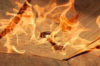 fire imposed on top of key and handwritten pages